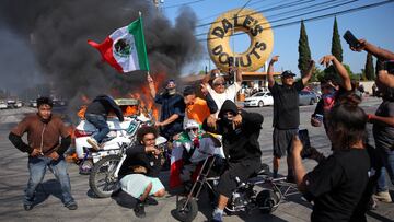 People hold Mexican flags and gesture next to a car in flames following multiple detentions by Immigration and Customs Enforcement (ICE), in the Los Angeles County city of Paramount, California, U.S., June 7, 2025. REUTERS/Daniel Cole TPX IMAGES OF THE DAY